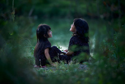 Side view of women sitting on land