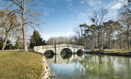 Arch bridge over river against sky