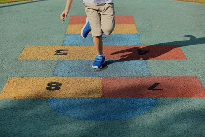 Low section of boy playing hopscotch 