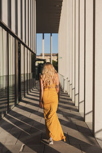 Rear view of woman standing at colonnade