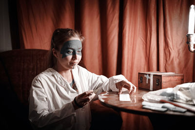 Portrait of young woman sitting on table