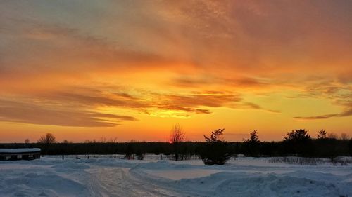 Snow covered landscape at sunset