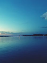 Scenic view of lake against blue sky at dusk