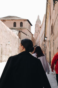 Rear view of woman walking along a street 