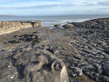 Scenic view of sea in front of rock against sky