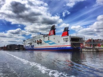 View of ship moored in river against cloudy sky