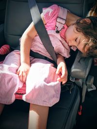 High angle view of girl sleeping on car seat