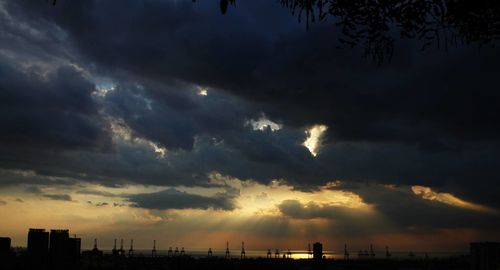 Silhouette of city against dramatic sky