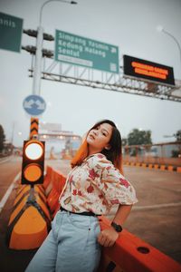 Woman standing on road sign