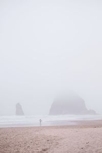 Scenic view of beach against sky during foggy weather