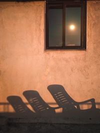 Empty chairs against wall in old building