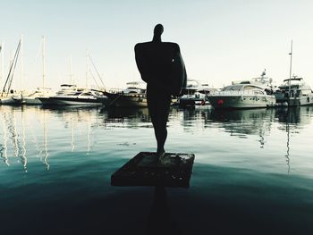 Rear view of man standing in marina