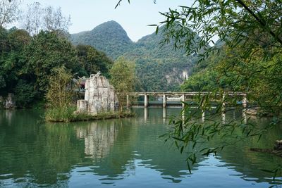 Scenic view of lake by trees against mountain