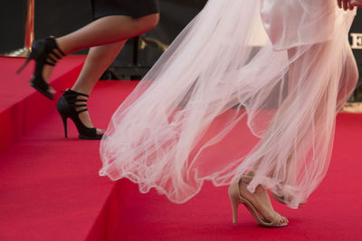 Low section of women in high heels on red carpet