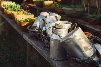 Empty metal milk jugs on wooden bench