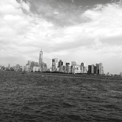 River in front of cityscape against cloudy sky