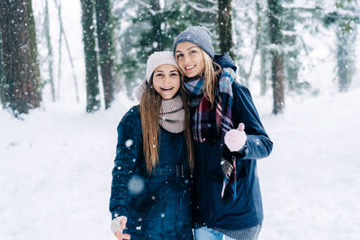 Young women walk in the park on a snowy winter day.
