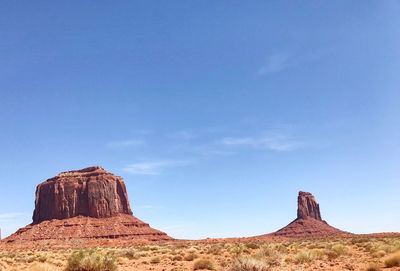 Rock formations on landscape against blue sky