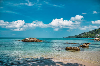 Empty, calm sandy crescent kalim bay, beach with turquoise blue clear water and cirrus cloudy sky