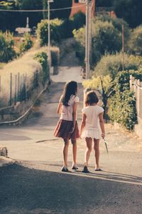 Rear view of women walking on road