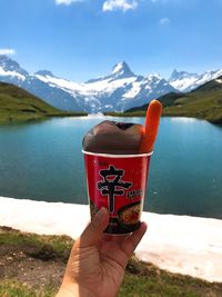 Midsection of person holding ice cream in lake