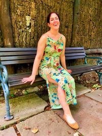 Portrait of a smiling young woman sitting on bench