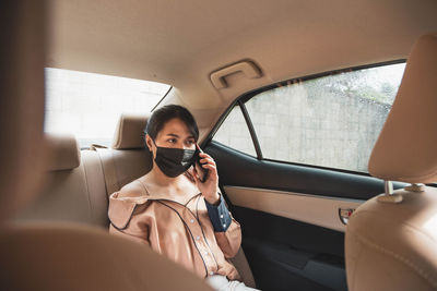 Woman using mobile phone while sitting in car