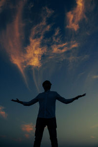 Rear view of silhouette man standing against sky during sunset