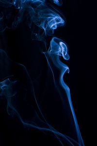 Close-up of blue smoke against black background