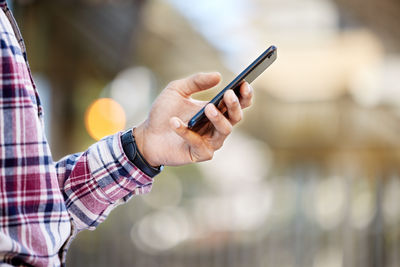 Midsection of man using mobile phone