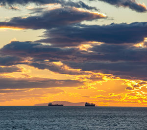 Scenic view of sea against dramatic sky during sunset