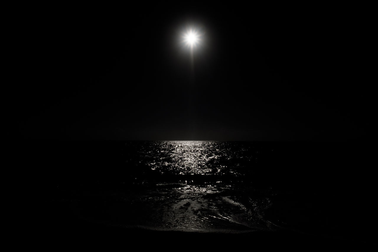 night, sea, water, beauty in nature, tranquility, moon, dark, no people, nature, tranquil scene, reflection, illuminated, scenics, outdoors, horizon over water, moonlight, sky, clear sky, black background