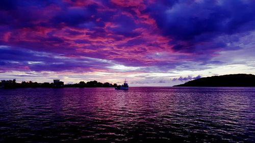 Scenic view of sea against dramatic sky at sunset