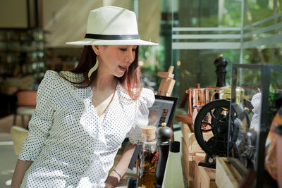 Close-up of woman wearing hat standing at store