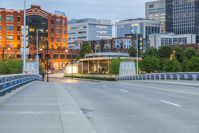 Road by buildings in city against sky at columbus ohio.