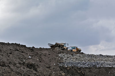 Low angle view of trucks at construction site against sky