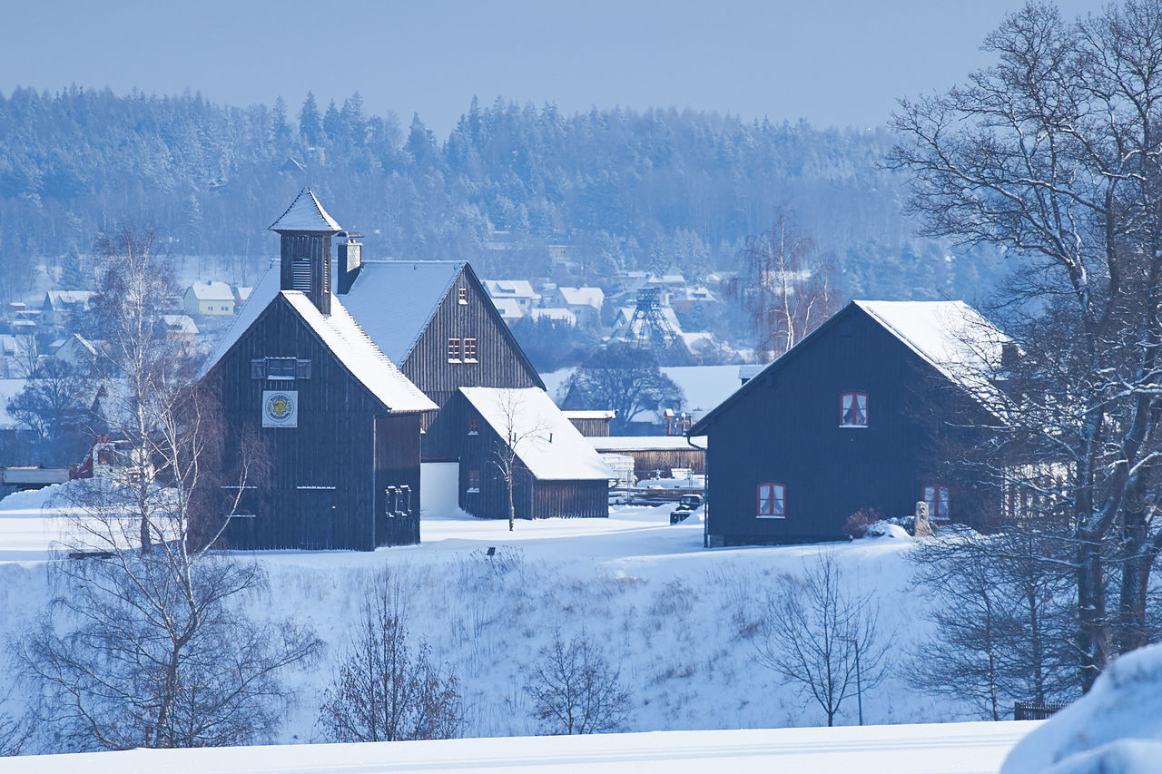 HOUSES IN WINTER AGAINST SKY