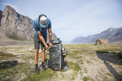 Man with umbrella on mountains against sky