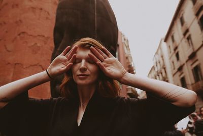 Low angle portrait of woman looking at city
