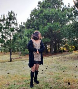 Teenage girl standing on grassy land in forest