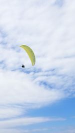 Low angle view of person paragliding against sky