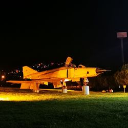 Airplane on field against sky at night