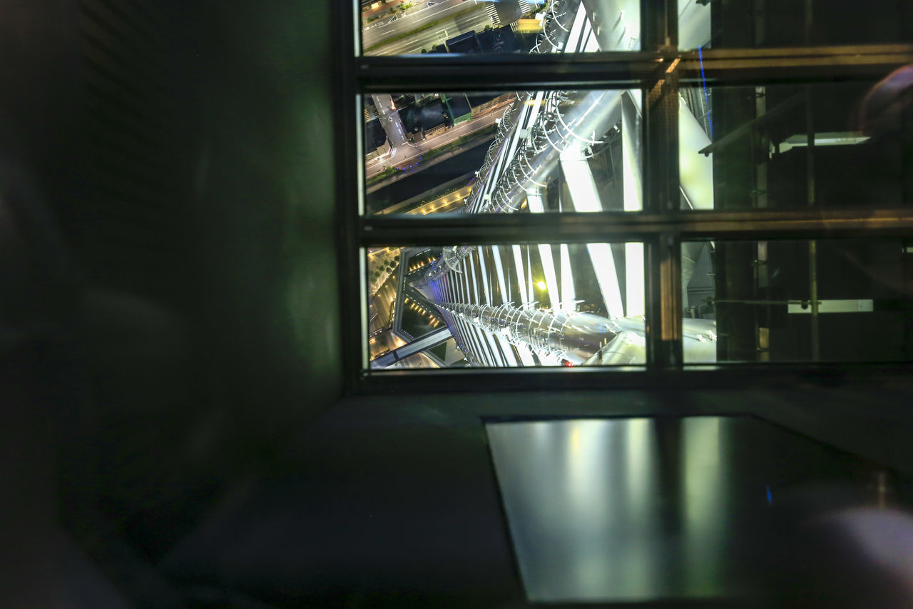 REFLECTION OF ILLUMINATED WINDOW ON MIRROR IN GLASS