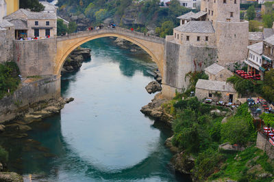 High angle view of arch bridge over river against buildings