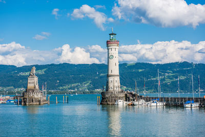 Lighthouse by sea against sky