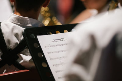 Close-up of musical note amidst people