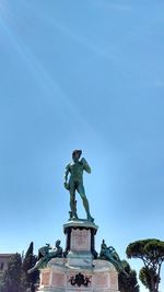 Low angle view of statue against blue sky