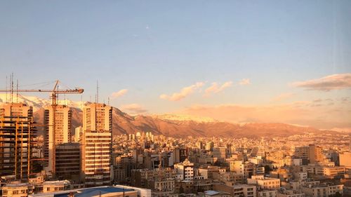 Buildings in city against sky during sunset