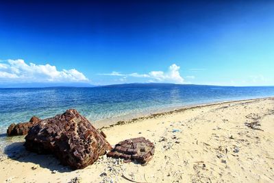 Scenic view of beach against blue sky