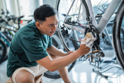 Side view of man repairing bicycle